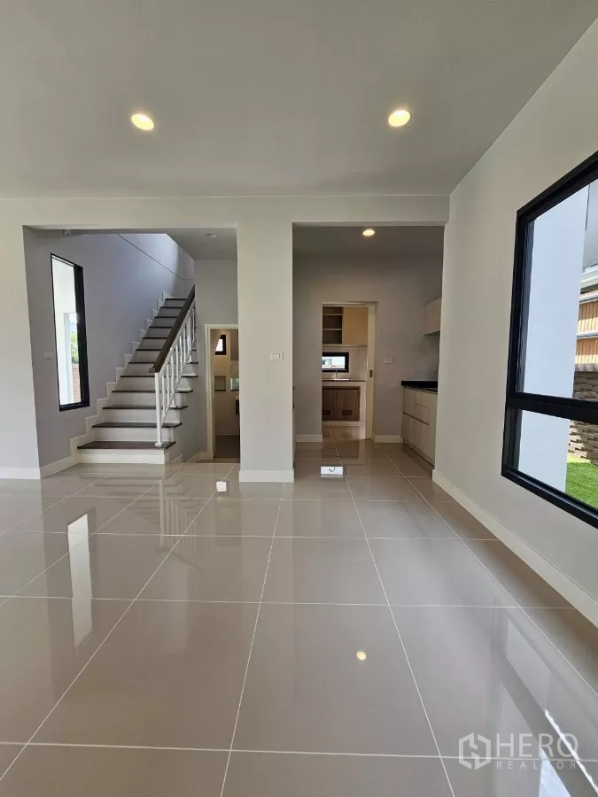 บ้าน ขายในLam Luk Ka, Pathum Thani - พื้นที่รับแขกเชื่อมบันไดและครัว พร้อมหน้าต่างบานใหญ่