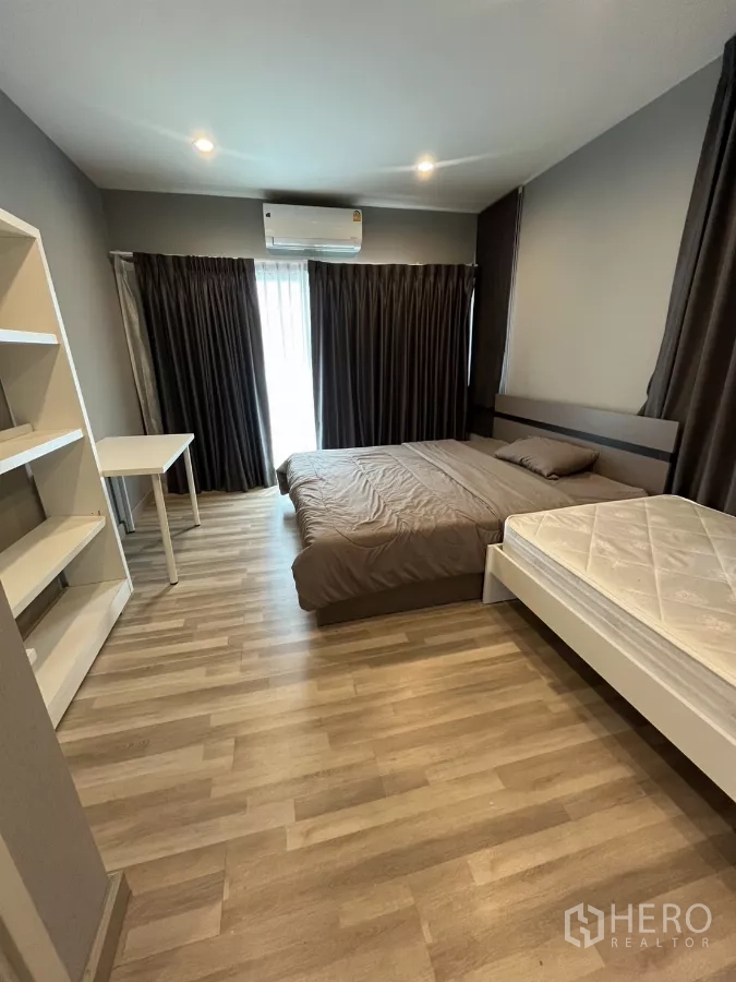 Detached House for rent in Suan Luang, Bangkok - Large bedroom with two beds, shelving and balcony door with air conditioner