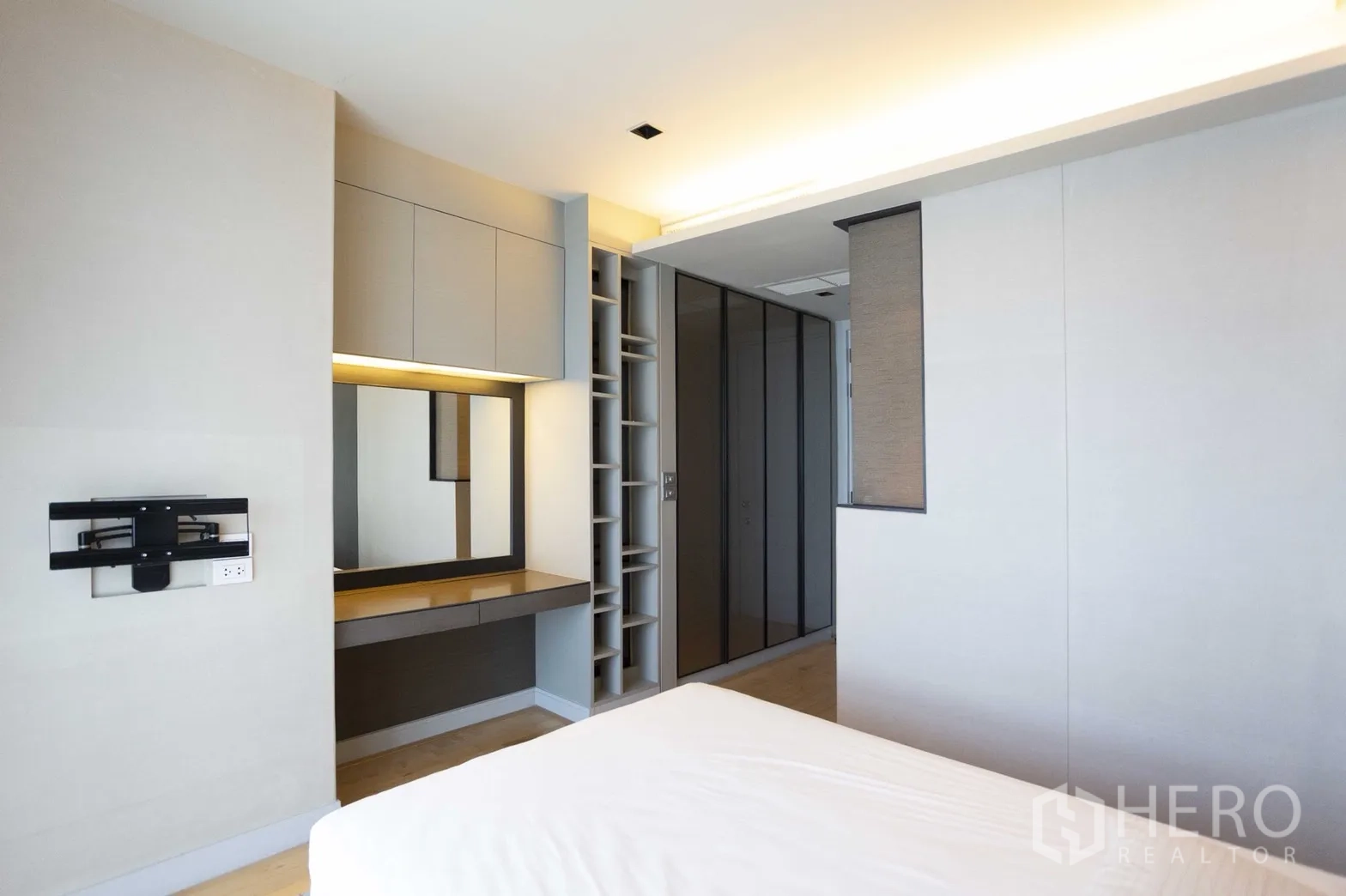 Condominium for rent in Pathum Wan, Bangkok - Bedroom with built-in wardrobes, dressing table and open shelving.