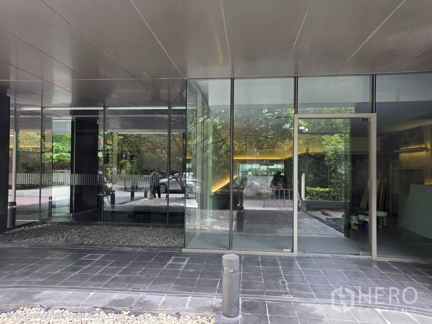 Retail Space for rent in Khlong Toei, Bangkok - Glass-walled retail entrance with covered walkway and greenery.