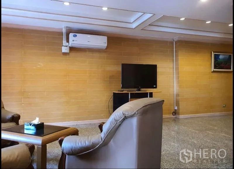 Condominium for rent in Ratchathewi, Bangkok - Living area wall with TV console, split air-conditioner and seating.