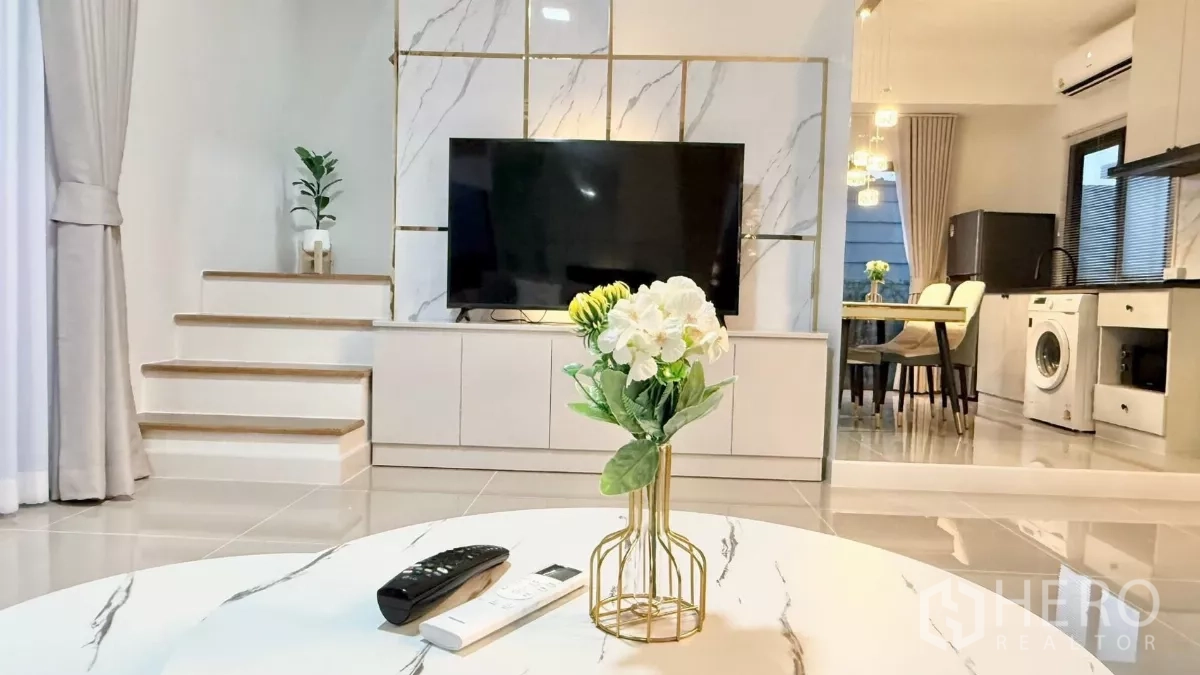 Townhouse for rent in Bang Phli, Samut Prakan - Built-in TV wall with marble finish and short stairway beside the living room.