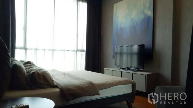 คอนโด ให้เช่าหรือขายในWatthana, Bangkok - ห้องนอนมีหน้าต่างเต็มบาน ตู้วางทีวี และภาพงานศิลป์ขนาดใหญ่