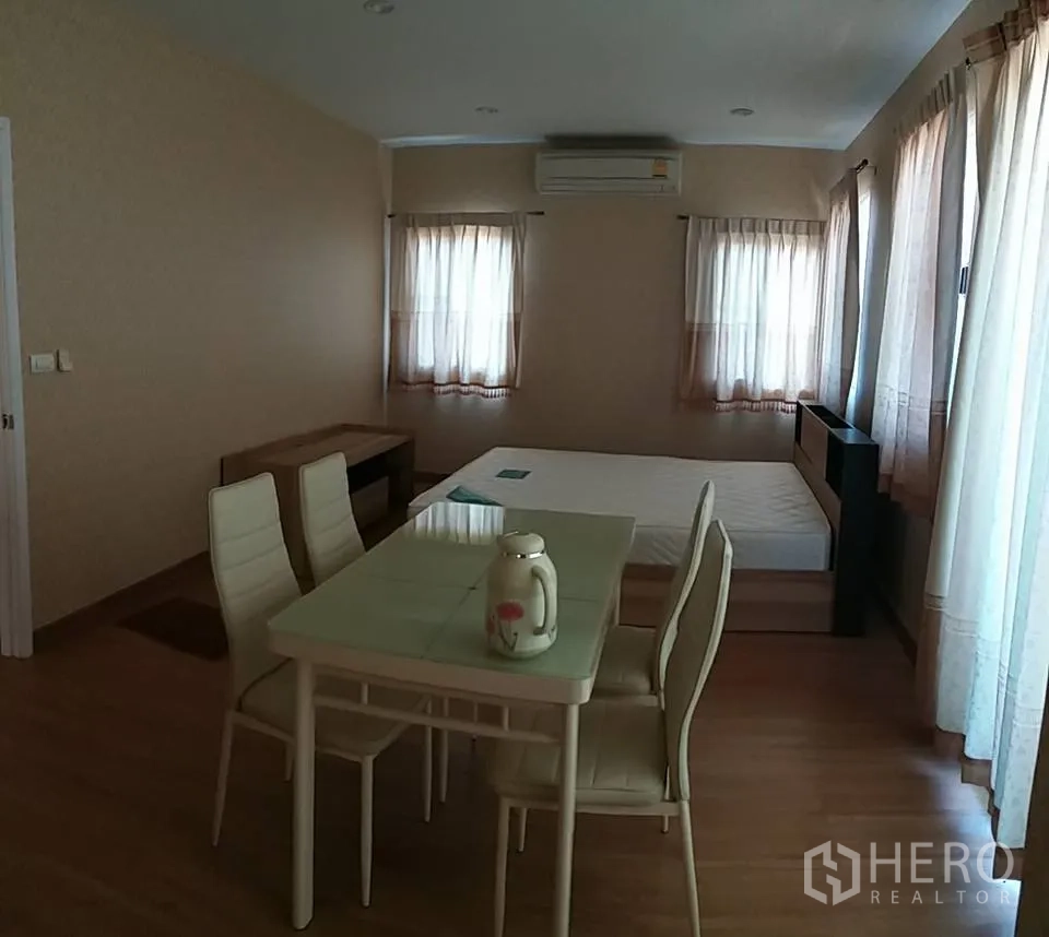 Detached House for rent in Pathum Thani - Master suite view with dining set, wood flooring and multiple windows for natural light