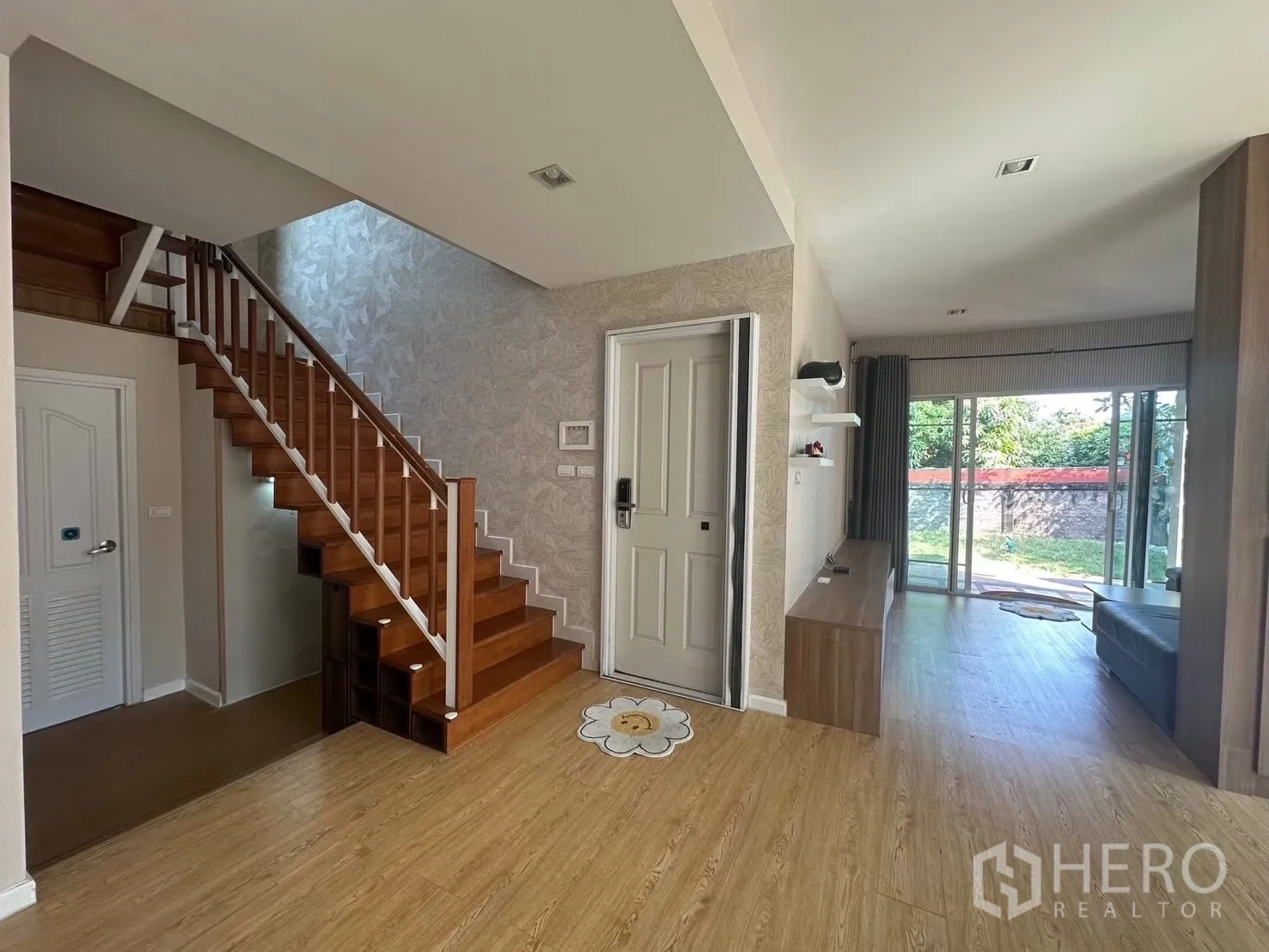 บ้าน ให้เช่า - โถงทางเข้ามีบันไดและประตูกระจกสไลด์เปิดสู่สวน