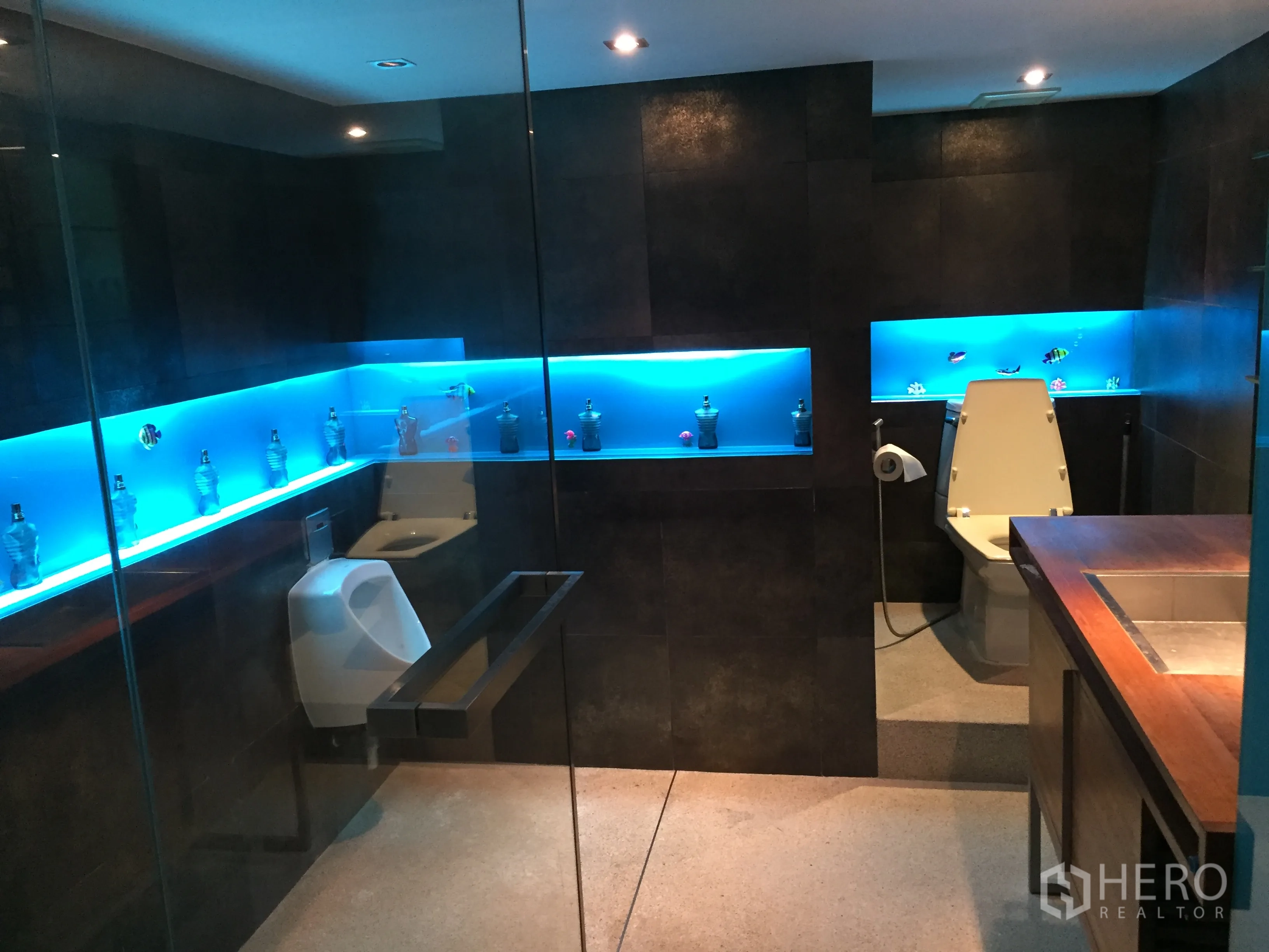 公寓 出租在Khlong Toei, Bangkok - 现代浴室，深色瓷砖、玻璃隔断与蓝色灯带壁龛