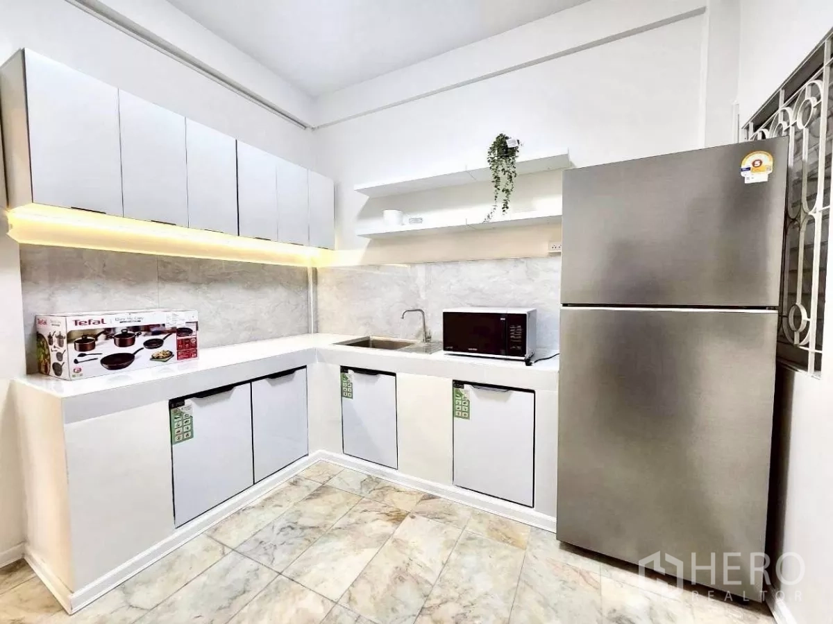 ทาวน์เฮาส์ ให้เช่าในHuai Khwang, Bangkok - ครัวตะวันตกสว่าง บิวท์อินรูปตัวแอล ตู้เย็น ไมโครเวฟ และไฟใต้ตู้