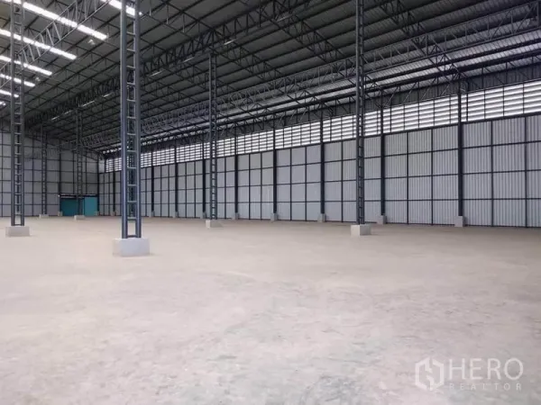 工厂 出租在Mueang Samut Prakan, Samut Prakan - 开放式生产空间，混凝土地面，金属夹芯墙体与青色服务门。