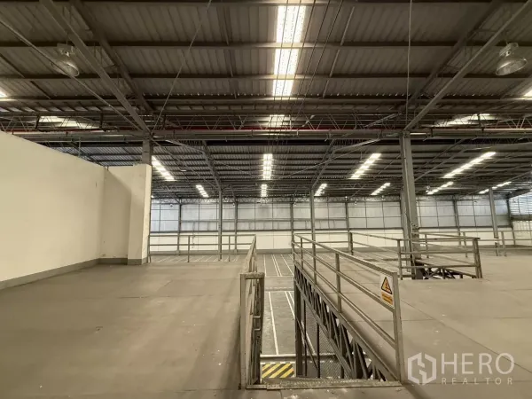 Factory for rent in Lat Krabang, Bangkok - Close-up of mezzanine walkway and guardrails beneath high-bay lighting inside the factory warehouse.