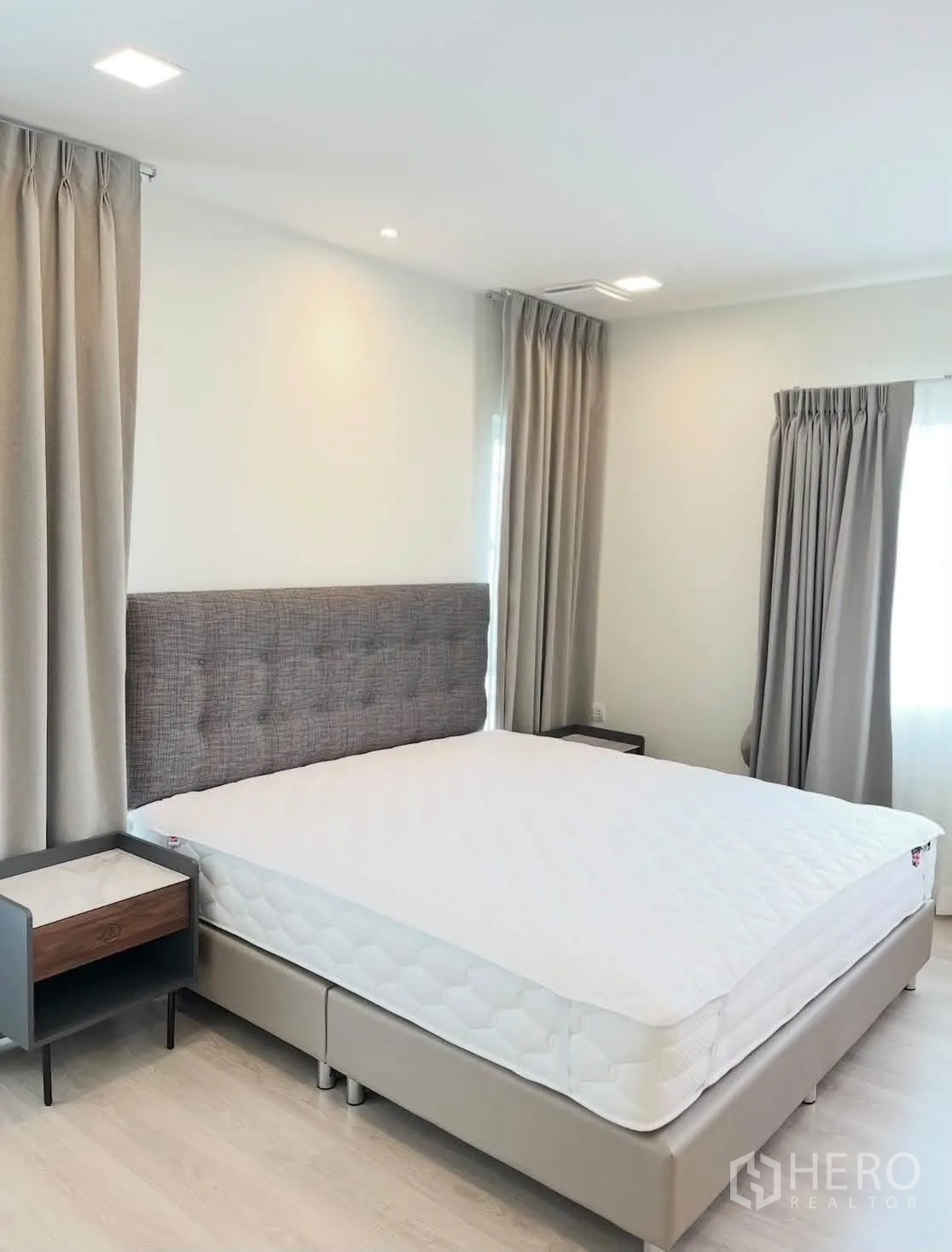 Detached House for rent in Bang Phli, Samut Prakan - Sunlit bedroom with gray headboard, side tables, and corner windows.