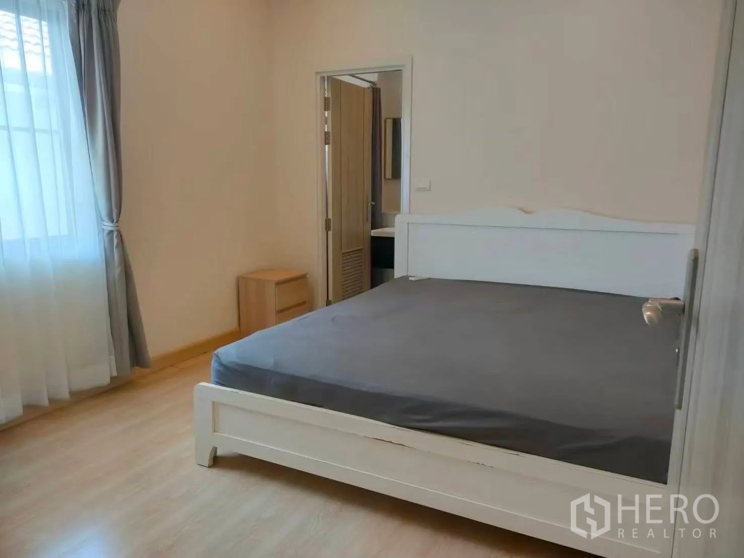 บ้านเดี่ยว for rent in Bang Phli, Samut Prakan - ห้องนอนเตียงสีขาว โต๊ะข้างเตียง พื้นไม้ และผ้าม่านโปร่ง