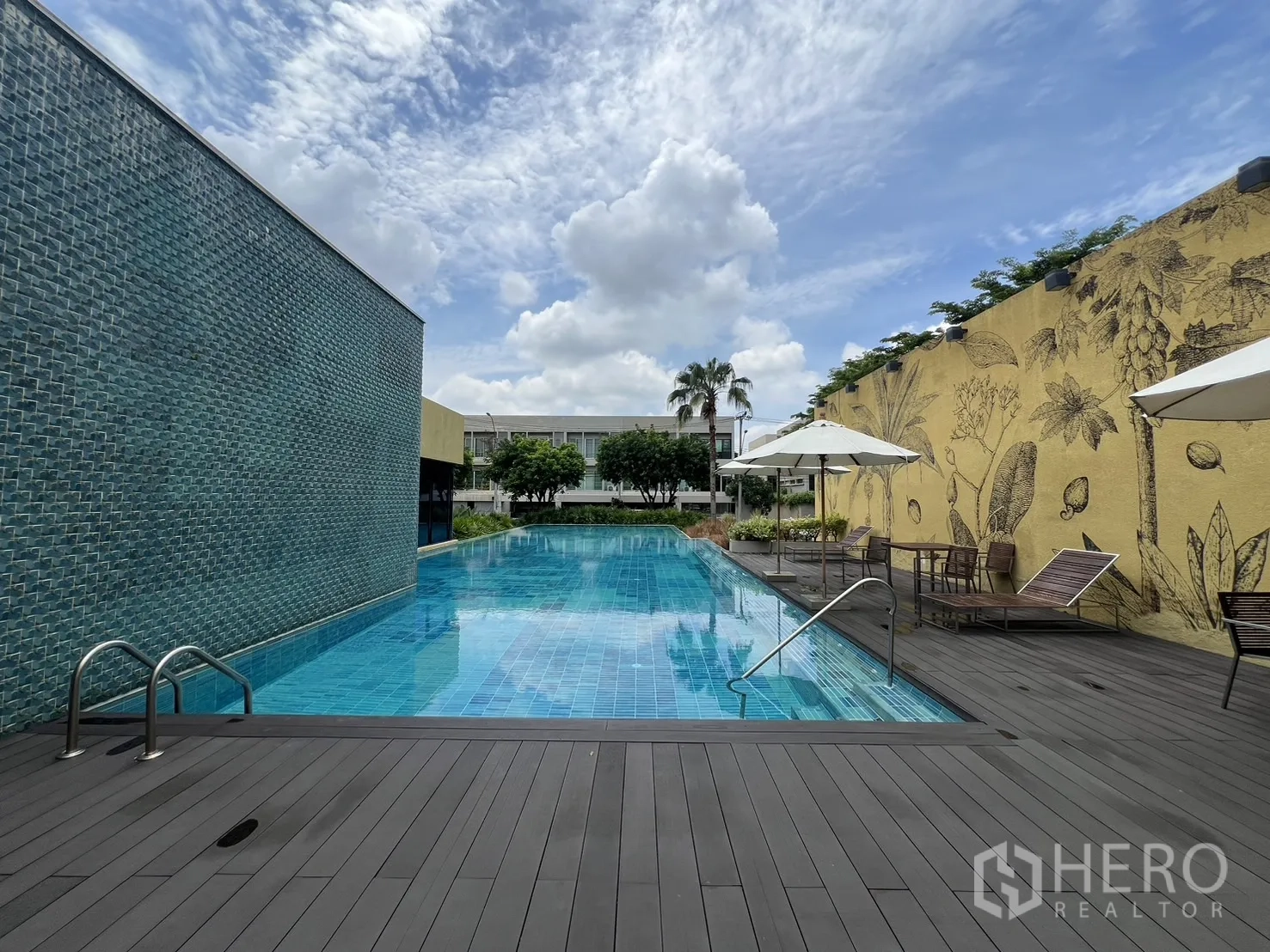 Townhouse for rent in Suan Luang, Bangkok - Wide view of the lap pool, deck seating, and blue sky.