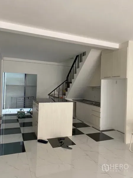 ทาวน์เฮาส์ ให้เช่าหรือขายในKhlong Toei, Bangkok - พื้นที่ครัวและนั่งเล่นแบบโอเพนพร้อมบันไดและไอส์แลนด์ พื้นตารางขาวดำ