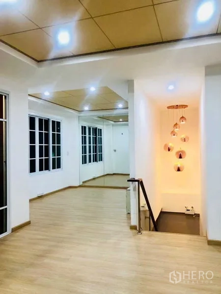 Home Office for rent or sale in Pak Kret, Nonthaburi - Bright landing or lounge with floor-to-ceiling windows, mirror wall and pendant lights by the stairs.
