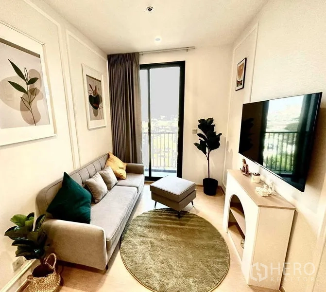 公寓 出售 - 客厅另一角度：沙发、脚凳、电视柜与通向阳台的采光。