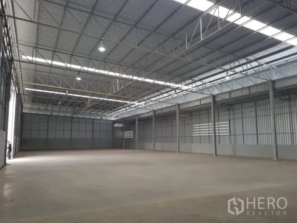 Warehouse for rent in Lat Krabang, Bangkok - Spacious warehouse interior with high steel truss roof, skylights, and smooth concrete floor.