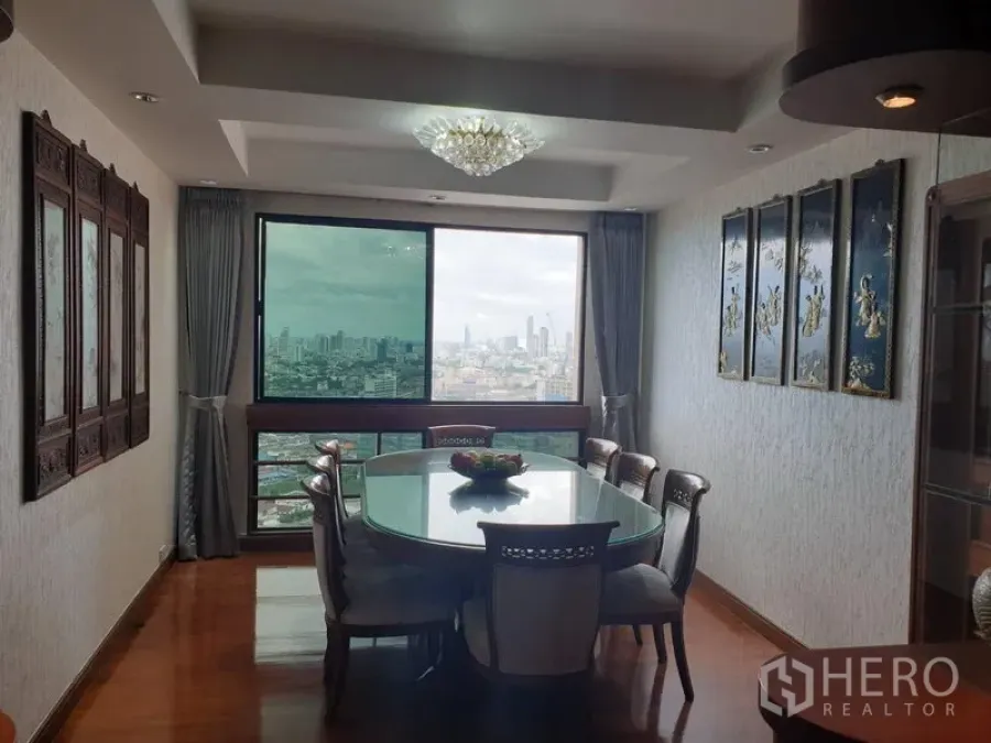 公寓 出租在Khlong Toei, Bangkok - 餐厅配水晶吊灯与玻璃餐桌，窗口尽览城市景观。