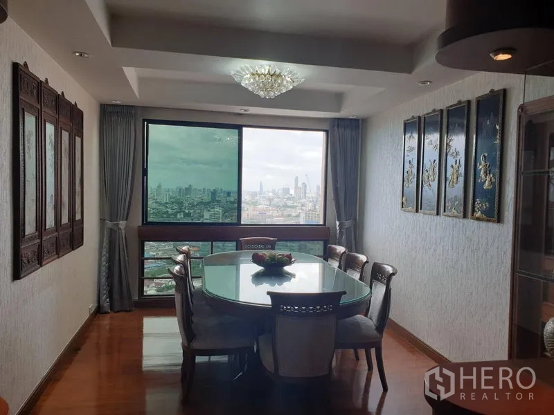 公寓 出租在Khlong Toei, Bangkok - 餐厅配水晶吊灯与玻璃餐桌，窗口尽览城市景观。