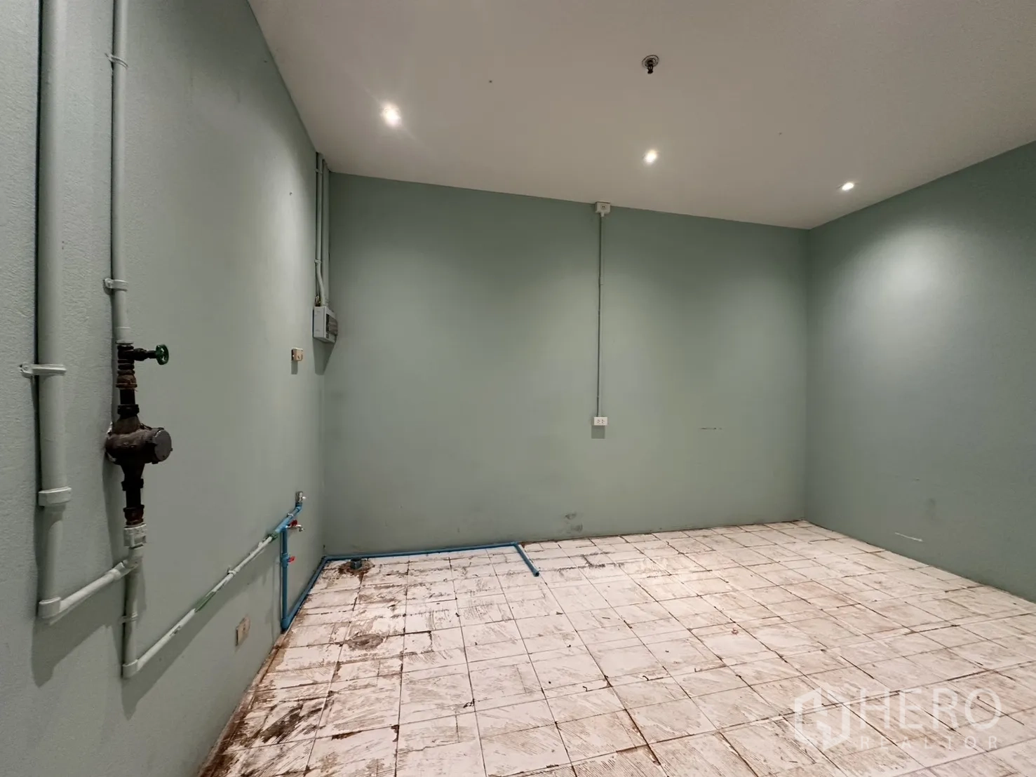 พื้นที่ขายของ for rent in Watthana, Bangkok - ห้องด้านหลังผนังสีเขียวอ่อน พื้นกระเบื้อง เดินท่อน้ำและท่อไฟฟ้า พร้อมไฟฝ้า