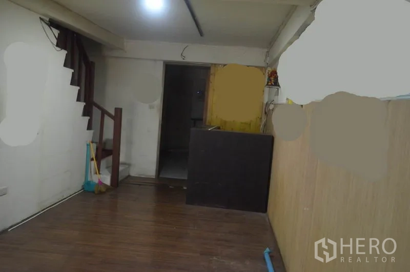 店屋 出租在Khlong Toei, Bangkok - 一层室内，木纹地板、楼梯与服务台。