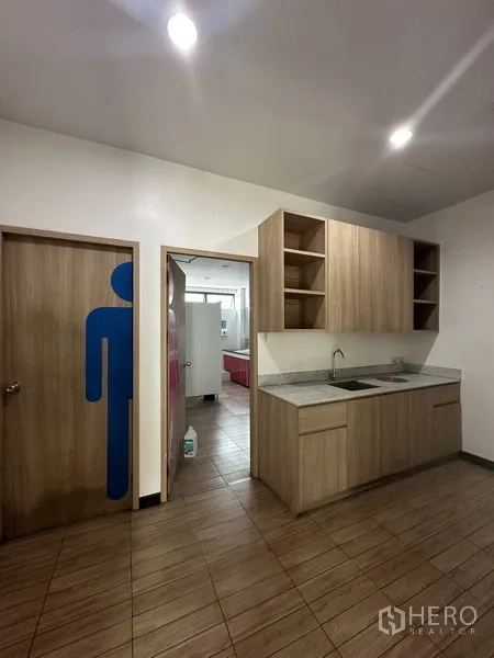 Office Space for rent - Restroom and kitchenette area with wooden cabinets and sink.