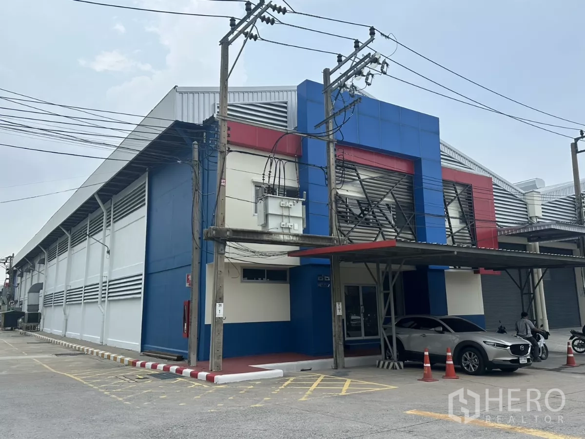 Factory for rent in Bang Phli, Samut Prakan - Side elevation of the warehouse building with canopy parking and electrical transformer.