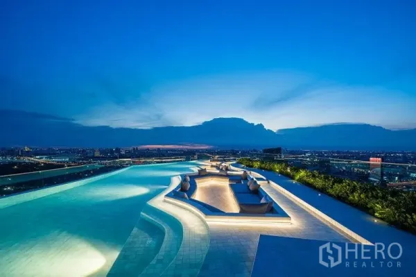 Condominium for sale in Chatuchak, Bangkok - Rooftop infinity pool at dusk with sculpted sunken seating and panoramic city views.