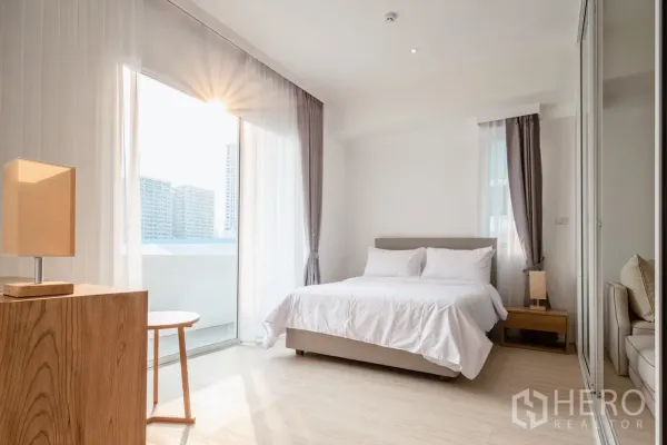 อพาร์ทเมนท์ ให้เช่าในKhlong Toei, Bangkok - ห้องนอนรับแสงธรรมชาติ พร้อมประตูกระจกออกระเบียงและผ้าม่านสูงจรดเพดาน