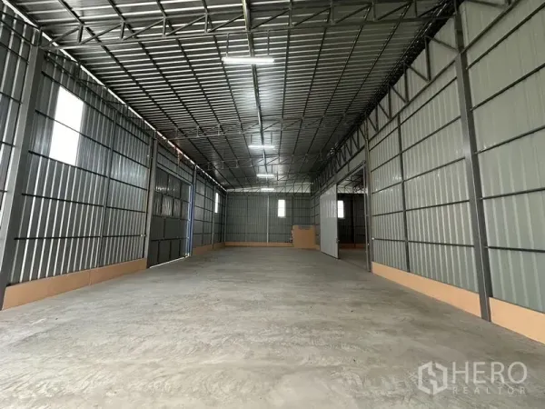 货栈 出租在Bueng Kum, Bangkok - 仓库内部空间，高钢桁架屋顶、混凝土地面与采光窗。