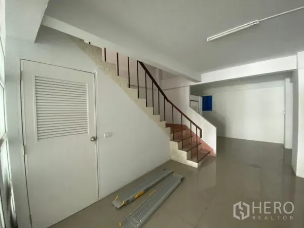 店屋 出租或出售在Suan Luang, Bangkok - 室内开放空间，楼梯与扶手通往上层。