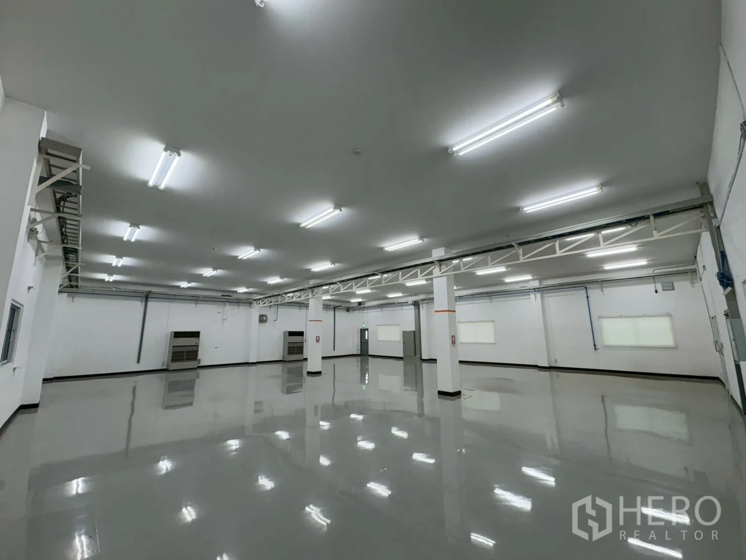 Factory for sale in Bang Bo, Samut Prakan - Open work area with sliding doors, columns and bright LED lighting.