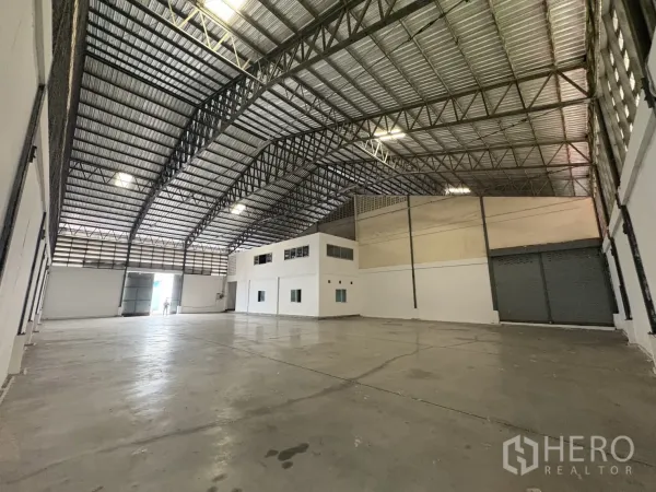 คลังสินค้า ให้เช่าในBang Phli, Samut Prakan - พื้นโกดังกว้างโล่ง มีประตูม้วนและบล็อกสำนักงานสีขาว