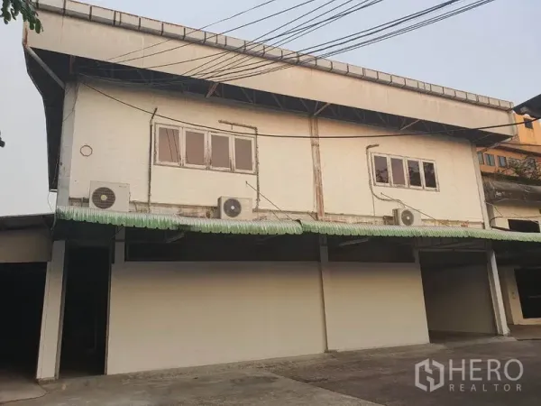 Home Office for rent in Watthana, Bangkok - Two‑storey warehouse exterior with covered parking and loading bays