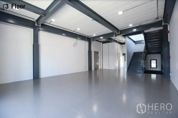 Warehouse for rent in Wang Thonglang, Bangkok - Third-floor open-plan workspace with steel beams, LED lighting and stairs.