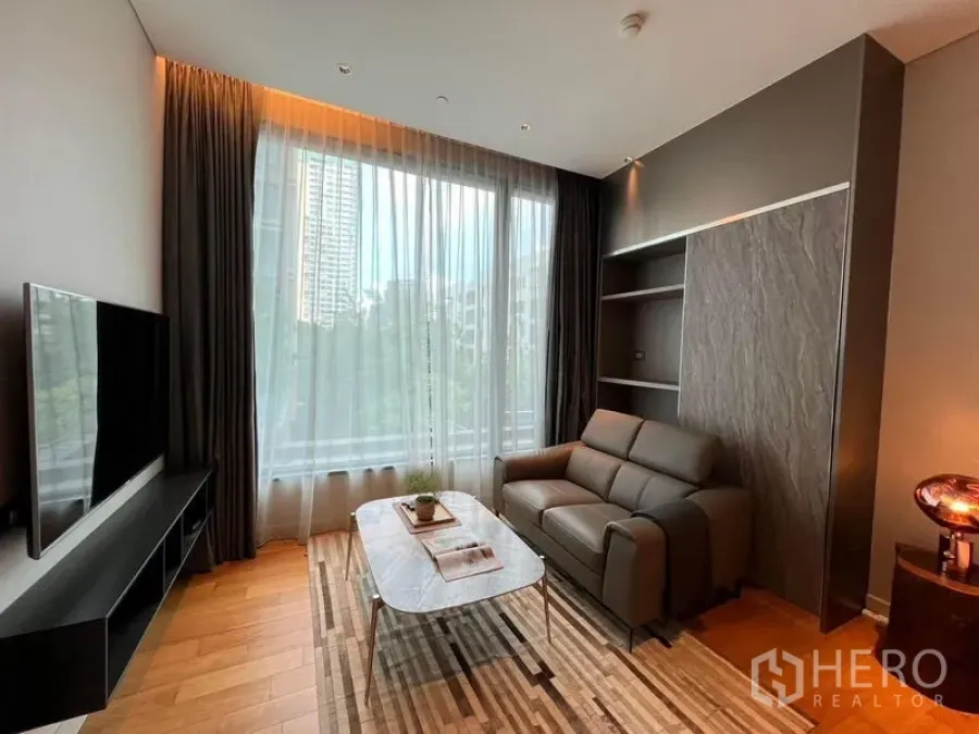 Condominium for rent in Pathum Wan, Bangkok - Living area with TV console, large curtained window, striped rug and city outlook