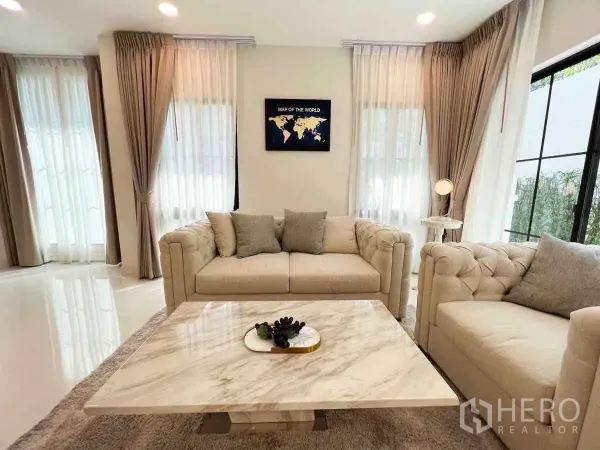 Detached House for rent or sale in Saphan Sung, Bangkok - Cozy lounge corner with beige sofas and marble table by black-framed windows