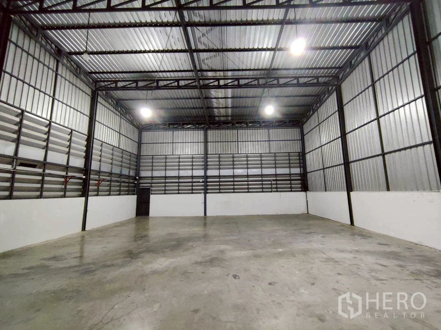 Warehouse for rent in Lam Luk Ka, Pathum Thani - Spacious warehouse interior with high ceiling, steel structure and polished concrete floor.
