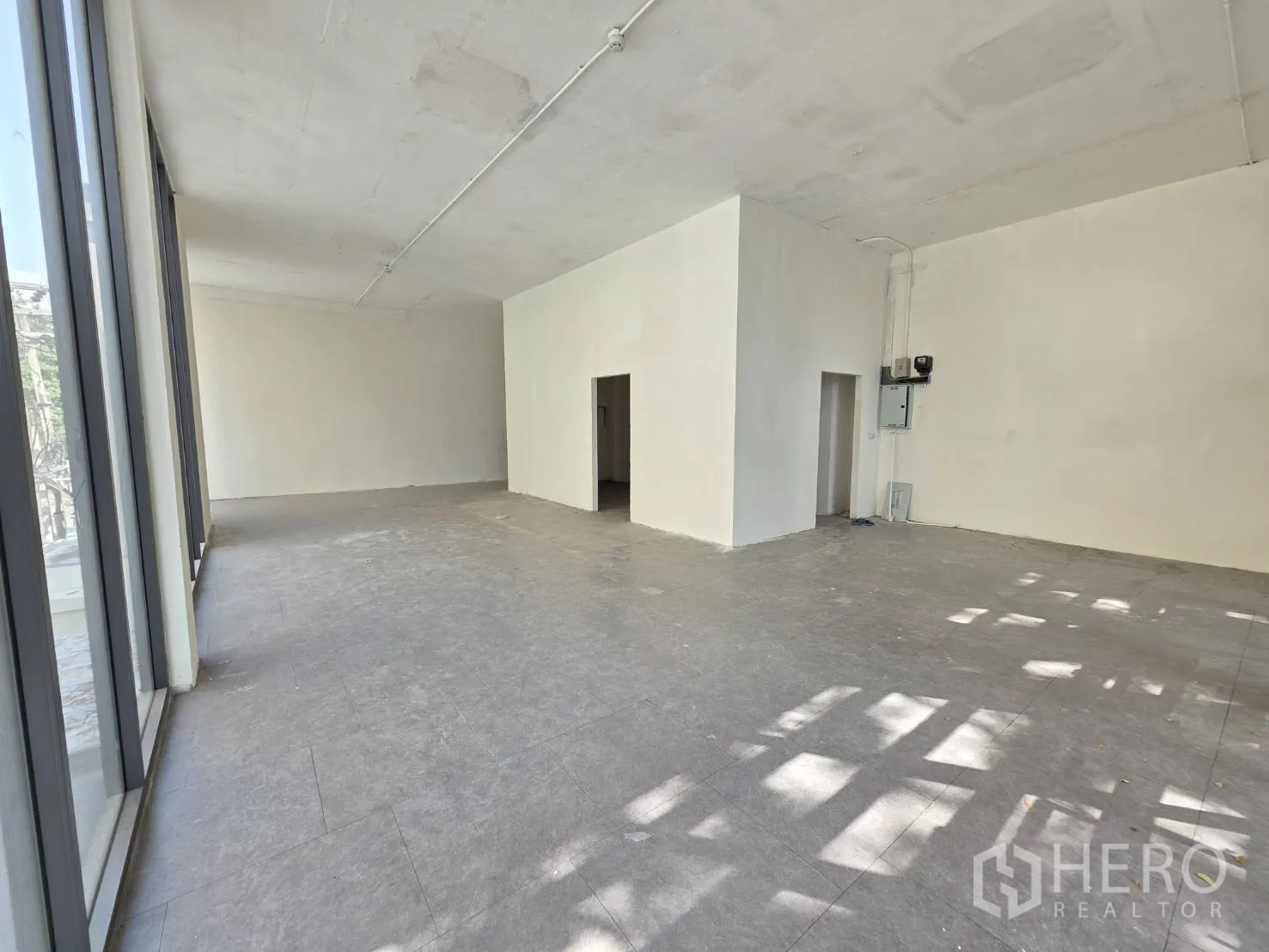 พื้นที่ขายของ for rent in Watthana, Bangkok - พื้นกระเบื้องสีเทาพร้อมหน้าต่างบานสูงและห้องอเนกประสงค์ด้านหลัง