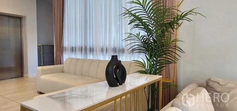 Detached House for rent in Bang Kapi, Bangkok - Lounge corner with modern sofa, indoor plant and lift access.