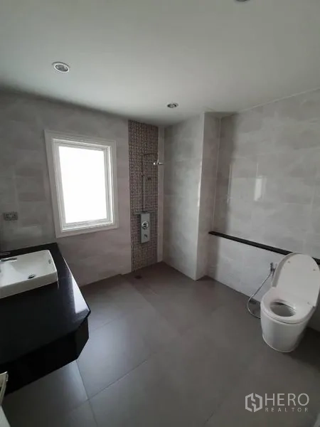 联排别墅 出租在Bang Na, Bangkok - 现代卫浴，窗户、步入式淋浴、坐便与黑色台面盥洗台。