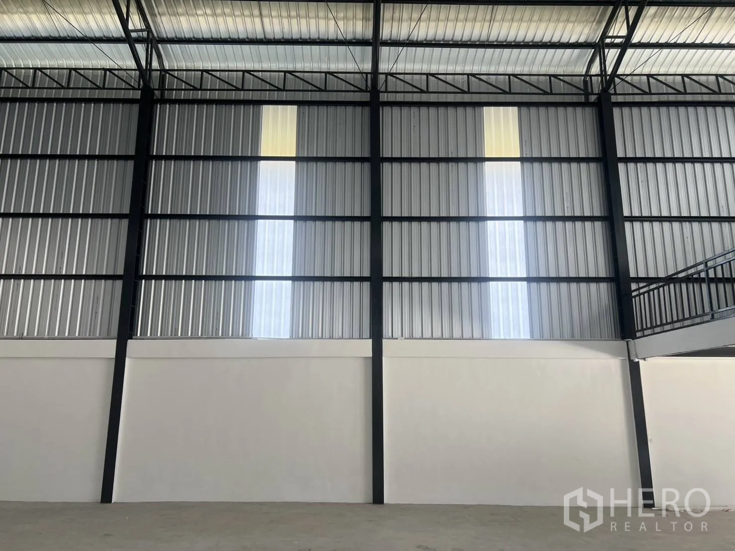 Warehouse for rent in Bang Phli, Samut Prakan - Interior wall with translucent sections and the edge of the mezzanine structure.