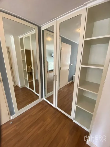 公寓 出租在Watthana, Bangkok - 转角衣柜，通顶镜面门与开放置物架的更衣区。