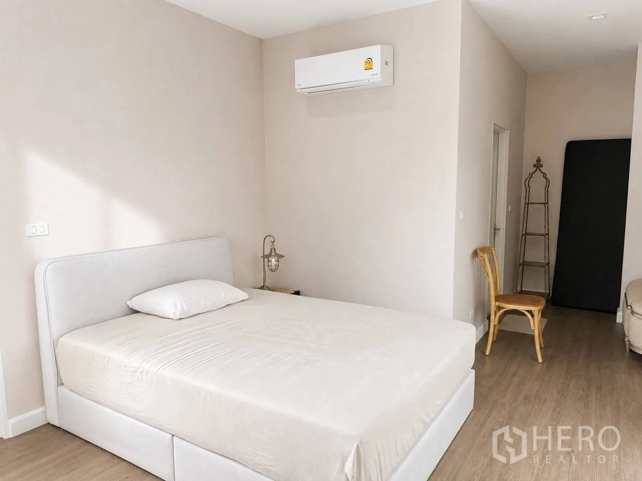 บ้านเดี่ยว for sale in Bang Kruai, Nonthaburi - ห้องนอนสว่าง เตียงสีขาว พื้นไม้ และเครื่องปรับอากาศ
