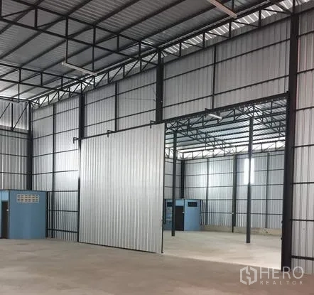 货栈 出租在Khan Na Yao, Bangkok - 高挑仓厅设金属推拉隔断，分隔为两个作业区。