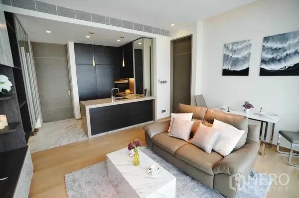 Condominium for rent in Bang Rak, Bangkok - Contemporary living room with sofa, marble coffee table and pendant-lit kitchen.