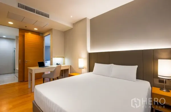 Condominium for rent in Bang Kho Laem, Bangkok - Cozy bedroom with king bed, padded headboard, work desk and warm lighting next to the ensuite.