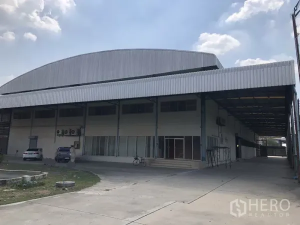 工厂 出租在Sai Noi, Nonthaburi - 工厂正面外观，带大面积遮雨装卸区与停车位，位于沙依诺暖武里