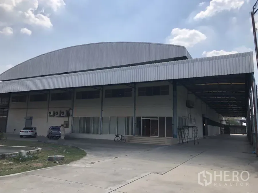 工厂 出租在Sai Noi, Nonthaburi - 工厂正面外观，带大面积遮雨装卸区与停车位，位于沙依诺暖武里