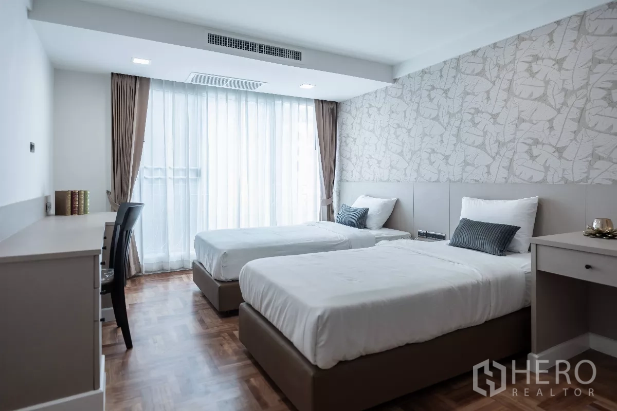 Apartment for rent - Twin bedroom with two single beds, study desk and sheer drapes.