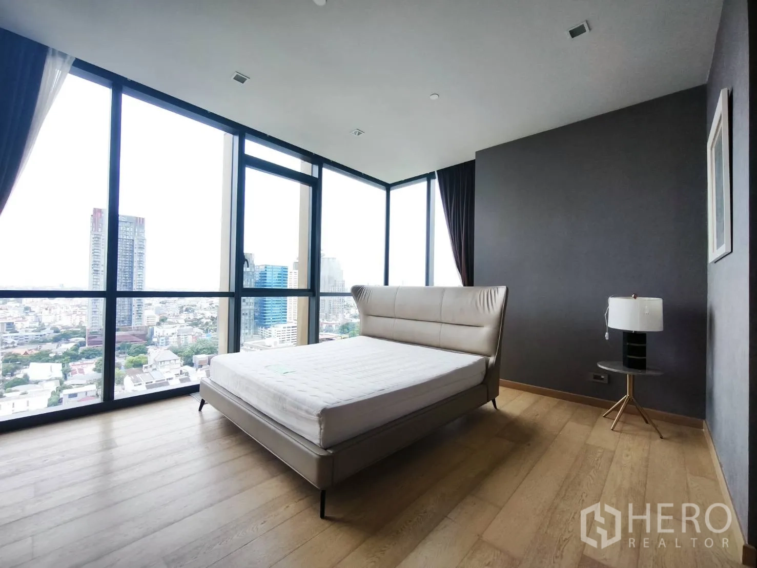 Condominium for rent in Watthana, Bangkok - Bedroom with light wood flooring and wide city views.